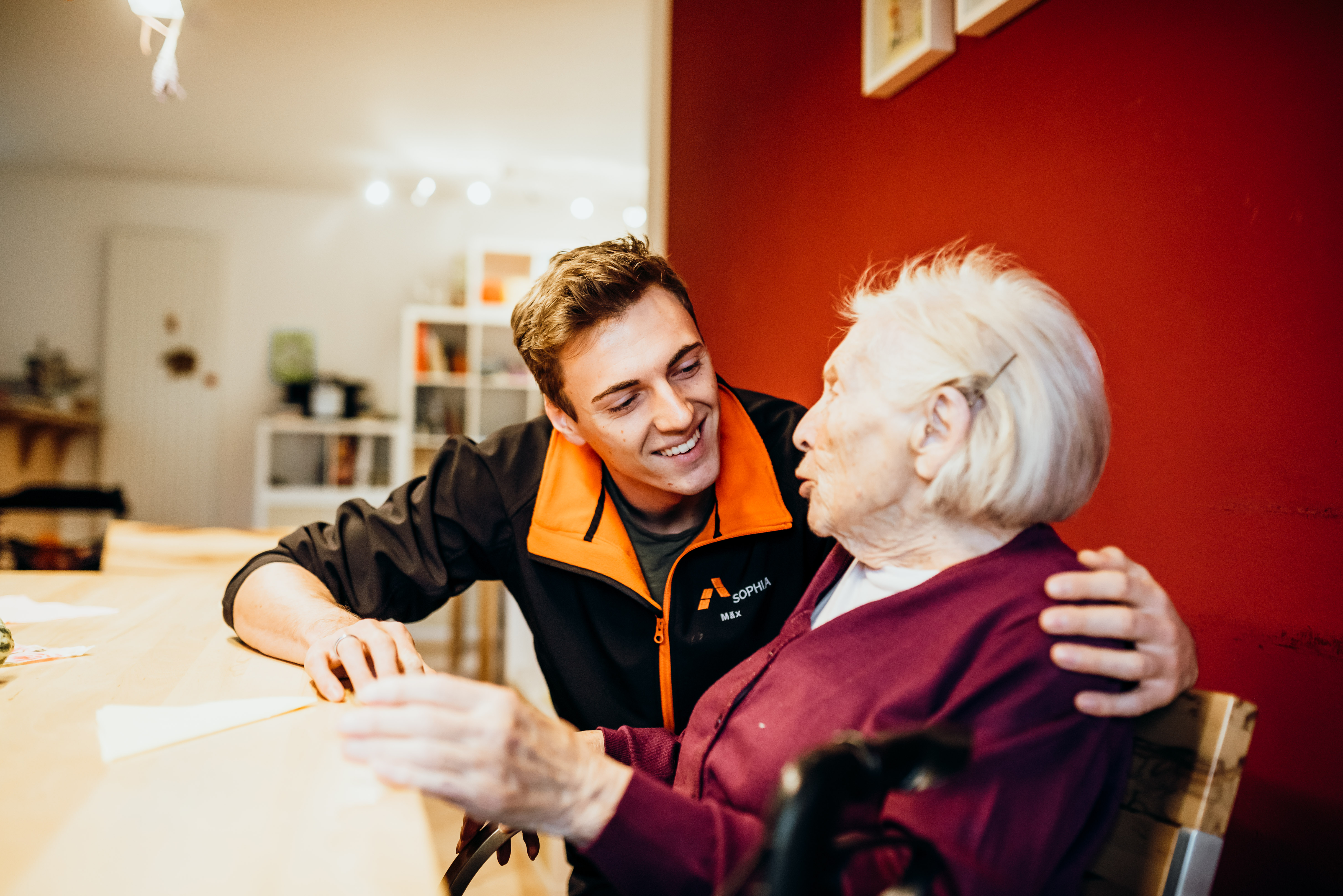 Ein Pfleger unterhält sich mit einer alten Frau.