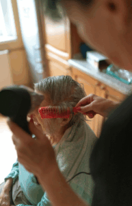 Frau kämmt einer älteren Frau die Haare